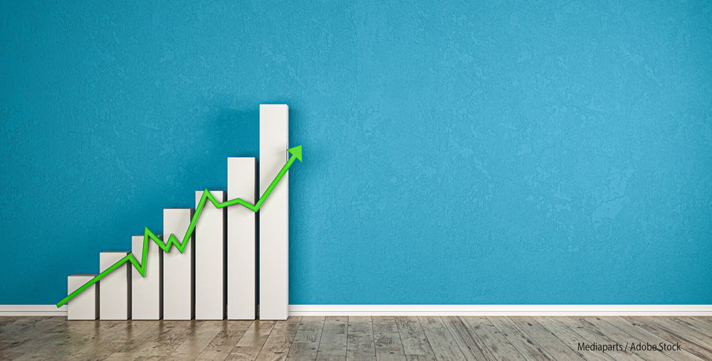 blaue Wand mit Balkendiagramm und ansteigendem grünen Pfeil